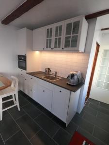 uma cozinha com armários brancos, um lavatório e uma mesa em Ranargata Apartment em Reiquiavique
