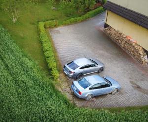 two cars parked in a driveway next to a house at Agroturystyka Willa Maria in Bystrzyca Kłodzka