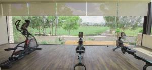 a gym with three exercise bikes in front of a large window at Viñedos San Francisco in San Miguel de Allende