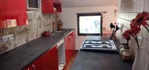a kitchen with red cabinets and a stove top oven at EMAÚS in Castellar del Riu