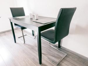 un tavolo nero e due sedie verdi di Klärchen's Stube a Telgte