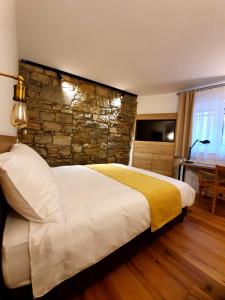 - une chambre avec un grand lit et un mur en pierre dans l'établissement Casa Isabella B&B, à Koper