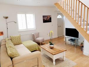 a living room with a couch and a tv at 'Little Eaton Margate' Perfectly located Town House by the Sea, with FREE parking! in Kent