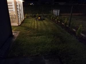 a yard lit up at night with a garden at MARKAS in Rewa