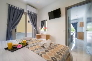 a bedroom with a bed with a tray of food on it at Linda Apartments Platanias in Platanias