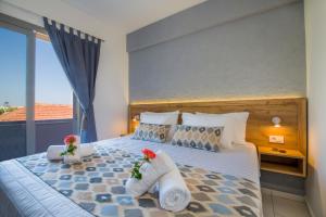 a bedroom with a large bed with flowers on it at Linda Apartments Platanias in Platanias