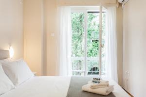 ein Schlafzimmer mit einem weißen Bett und Handtüchern darauf in der Unterkunft La casa di Plaka in Athen