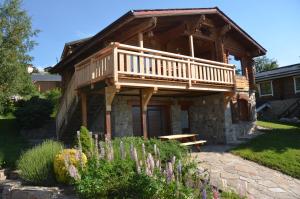 uma cabina de madeira com um deque e um banco em Chalet Rouge Sorbier em Font-Romeu