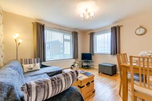 a living room with a couch and a table at Seaview - Cheviot Court in Broadstairs