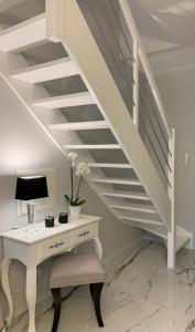 a white desk with a lamp and a staircase at Leo Royal Apartament Pobierowo in Pobierowo +16 photos