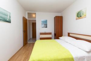 um quarto com uma cama grande e um cobertor amarelo em Apartman Meira br 2 em Mimice