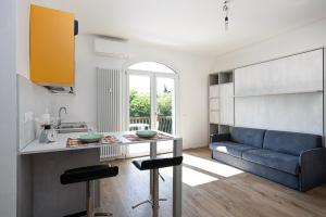 cocina y sala de estar con sofá azul en Appartamento Perla, en Peschiera del Garda