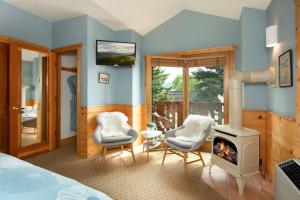 a bedroom with a bed and two chairs and a fireplace at The Alpine House in Jackson