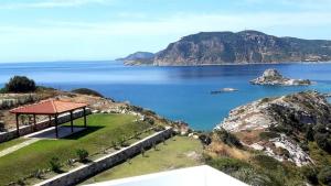 a gazebo on a hill next to the water at Panorama Studios in Kefalos