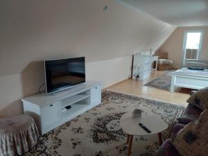 a living room with a flat screen tv and a couch at Lootsi puhkemaja in Kuressaare