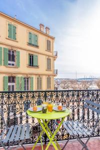 a table on a balcony with a view of a building at Astoux YourHostHelper in Cannes