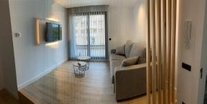 a living room with a couch and a television at APARTAMENTOS LLAMIEVA in Posada de Llanes