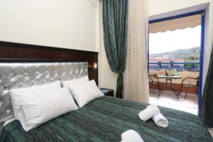 a hotel room with a bed with two towels on it at Philoxenia Village Hotel-Studios in Pefkochori +49 photos