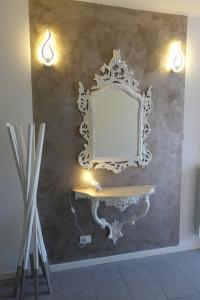 um espelho numa parede com uma mesa e luzes em casa David em Siena