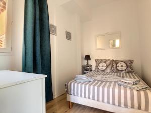 um quarto com uma cama com uma cortina verde em Hanna-Logis em Antibes
