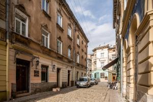 an alley with buildings and a car parked on a street at Apartment On Yana Zhizhky in Lviv