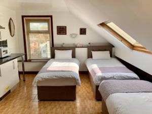 a attic room with three beds in it at Manchester Stay Hotel in Manchester