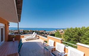 Un balcón con sillas blancas y vistas al océano. en Apartman Relax, en Podstrana