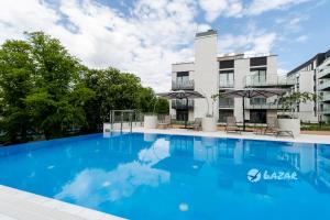 a large blue swimming pool in front of a building at Lazar Apartamenty Nadmorskie Tarasy in Kołobrzeg