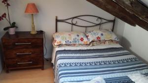 a bedroom with a bed with pillows and a dresser at COZY ROMANTIC MALASAÑA in Madrid +10 photos