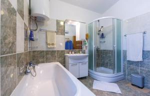 Un baño con bañera, lavabo y ducha. en Apartman Relax, en Podstrana 27 fotos más