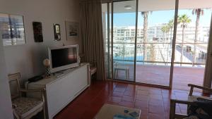 un soggiorno con TV e una grande finestra di Lagos Marina - Exclusive Apartment with a Balcony a Lagos