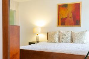 1 dormitorio con 1 cama y una pintura en la pared en Pueblito Escondido By Hola Home and Land, en Playa del Carmen