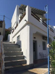 a white house with stairs leading up to the door at Fotini Studios in Emborios Kalymnos