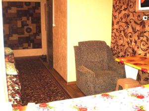 uma sala de estar com uma cadeira e uma mesa em Небольшая студия, пр. Центральный, 148, 1этаж-9этажного дома, WI-FI, 2 дивана и 2 кресла em Nikolayev
