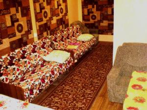 um sofá longo com almofadas num quarto em Небольшая студия, пр. Центральный, 148, 1этаж-9этажного дома, WI-FI, 2 дивана и 2 кресла em Nikolayev