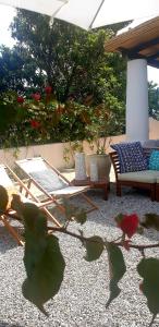 a patio with chairs and a table and a bench at Villa Euribia in Santa Marina Salina