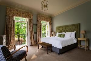 a bedroom with a bed and a chair and windows at Vazisubani Estate in Vazisubani