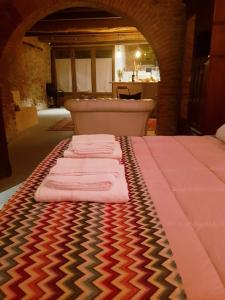 un gruppo di asciugamani in un letto in una camera di L' Atelier Tuscany a Peccioli