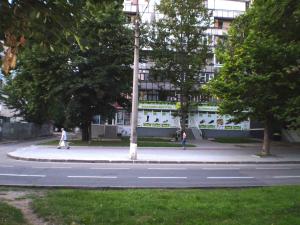 duas pessoas a andar numa rua em frente a um edifício em Небольшая студия, пр. Центральный, 148, 1этаж-9этажного дома, WI-FI, 2 дивана и 2 кресла em Nikolayev