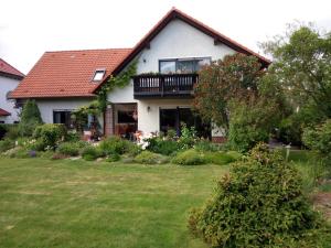 een huis met een balkon op een tuin bij Große Ferienwohnung am grünen Stadtrand in Erfurt