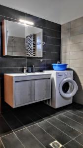 a bathroom with a sink and a washing machine at Ourania luxury apartment in Keramotí +27 photos