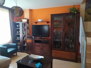 una sala de estar con un centro de entretenimiento con TV en Casa mireia en Soria