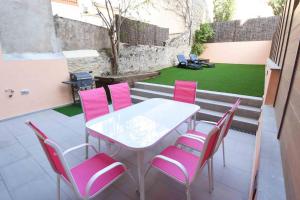 une table et des chaises sur une terrasse avec une pelouse dans l'établissement APG Girona Carme 19, à Gérone