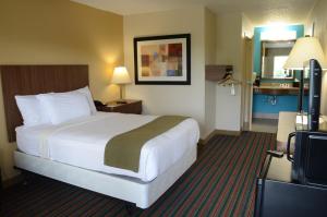 a hotel room with a bed and a television at Baymont by Wyndham Nashville Airport in Nashville