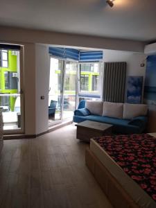 Studio Alezzi Beach Resort في مامايا نورد نافورداي: غرفة معيشة مع أريكة زرقاء وغرفة معيشة +23 صورة