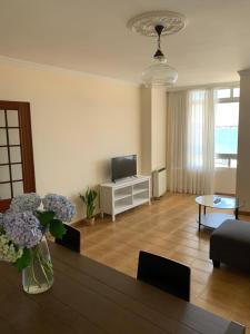 a living room with a vase of flowers on a table at Piso en el malecón de Riveira con vistas a las Rias Baixas. Ideal para familias. 140m in Ribeira