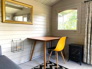 a room with a table and a chair and a mirror at Holly Tree Cottage - 3 bedrooms and large garden with optional glamping double outside in Lymington