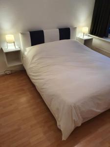 - un grand lit blanc avec deux lumières sur deux tables dans l'établissement Single family home in Hillegersberg - Schiebroek, à Rotterdam