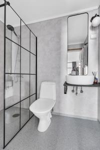 a bathroom with a toilet and a sink and a mirror at Lille Hotell in Arendal