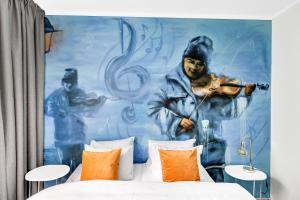 a bedroom with a mural of a man playing a violin at Lille Hotell in Arendal